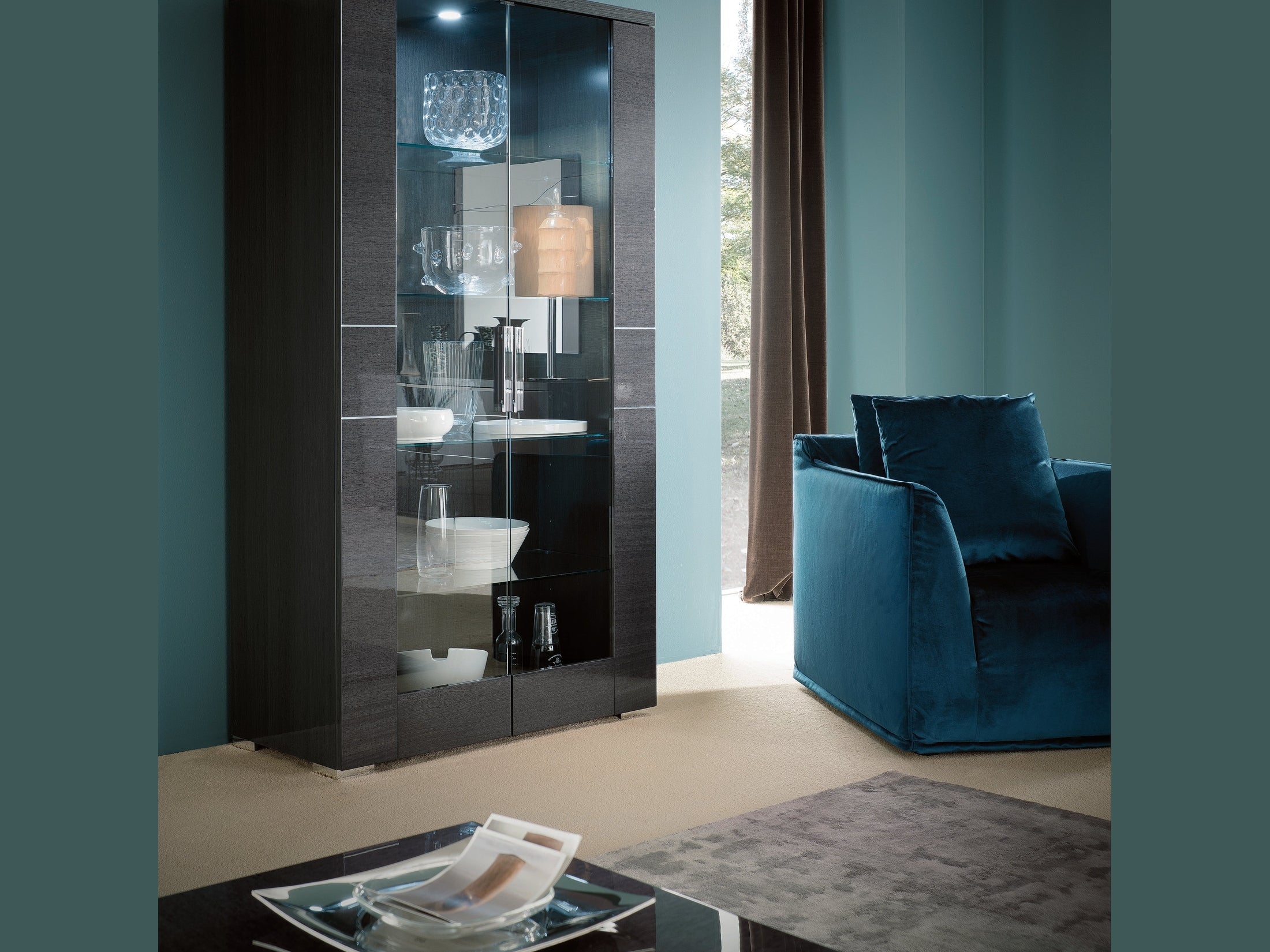 Modern living room with a dark wooden display cabinet and blue sofa.