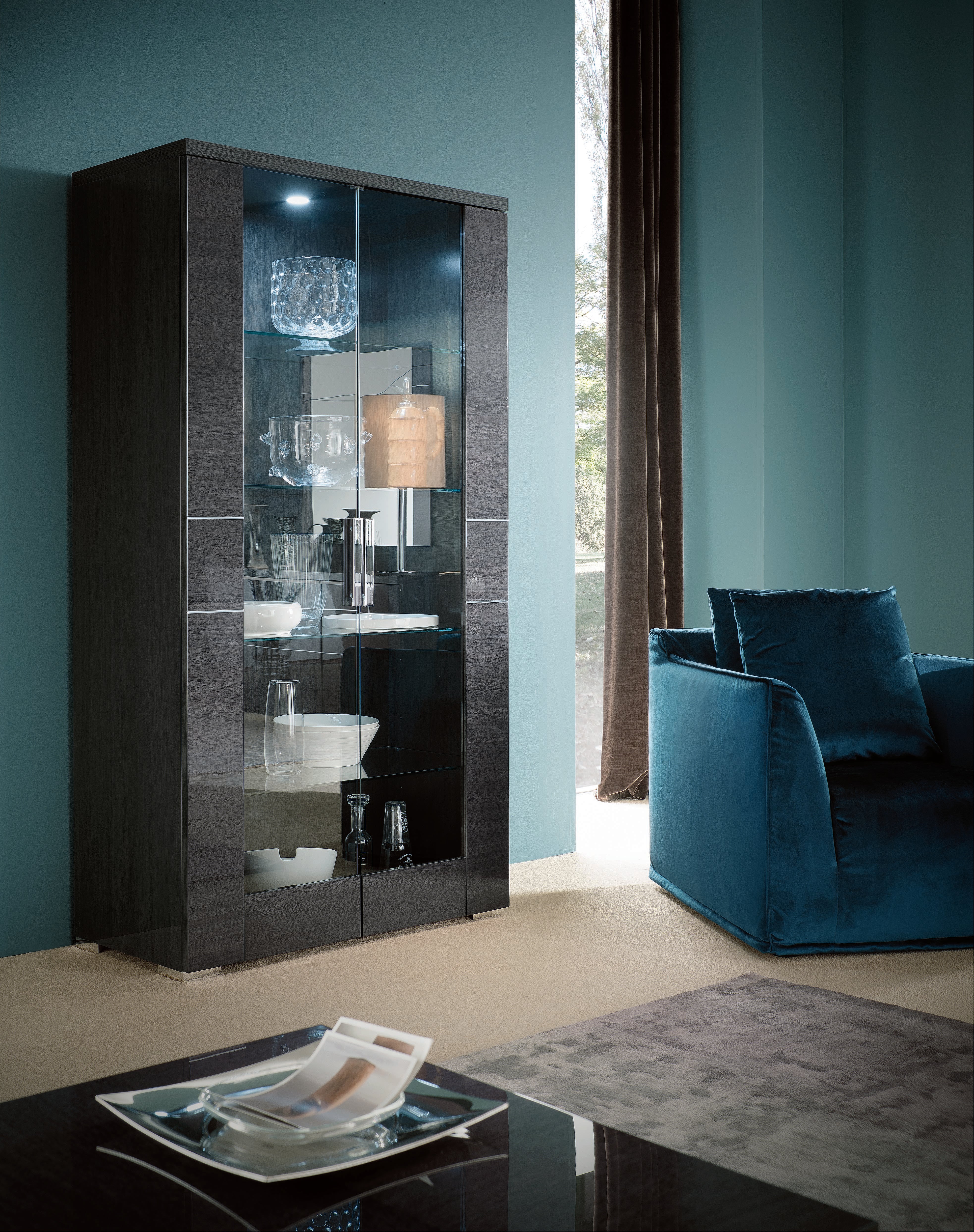 Modern living room with a dark wooden display cabinet and blue sofa.