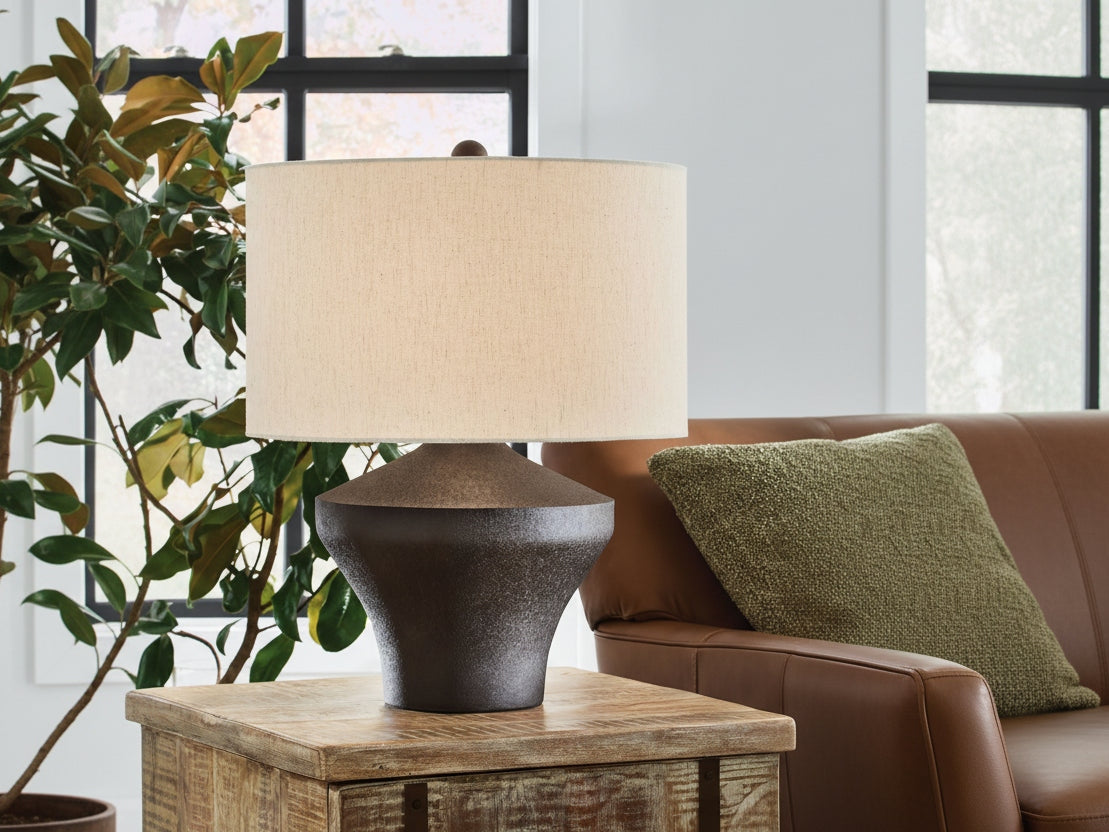 The Dolanham table lamp with a beige shade on a wooden table in a home setting.
