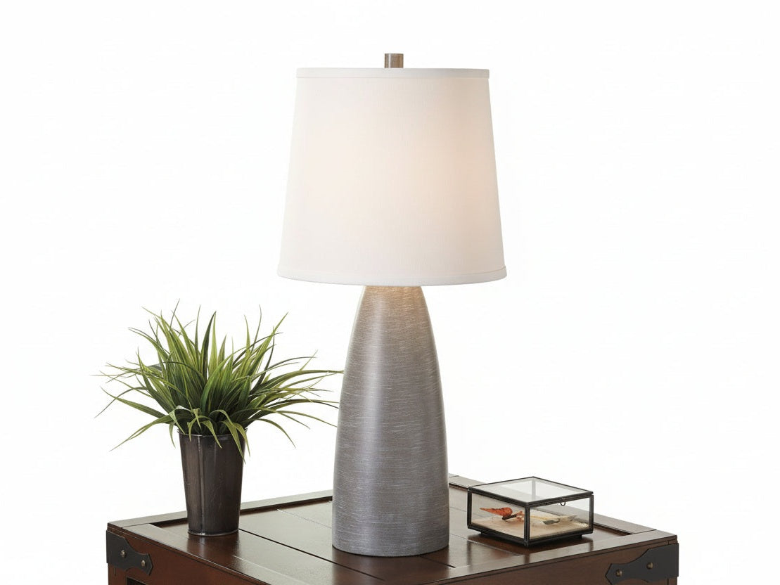Table lamp on a wooden surface with a decorative wall in the background