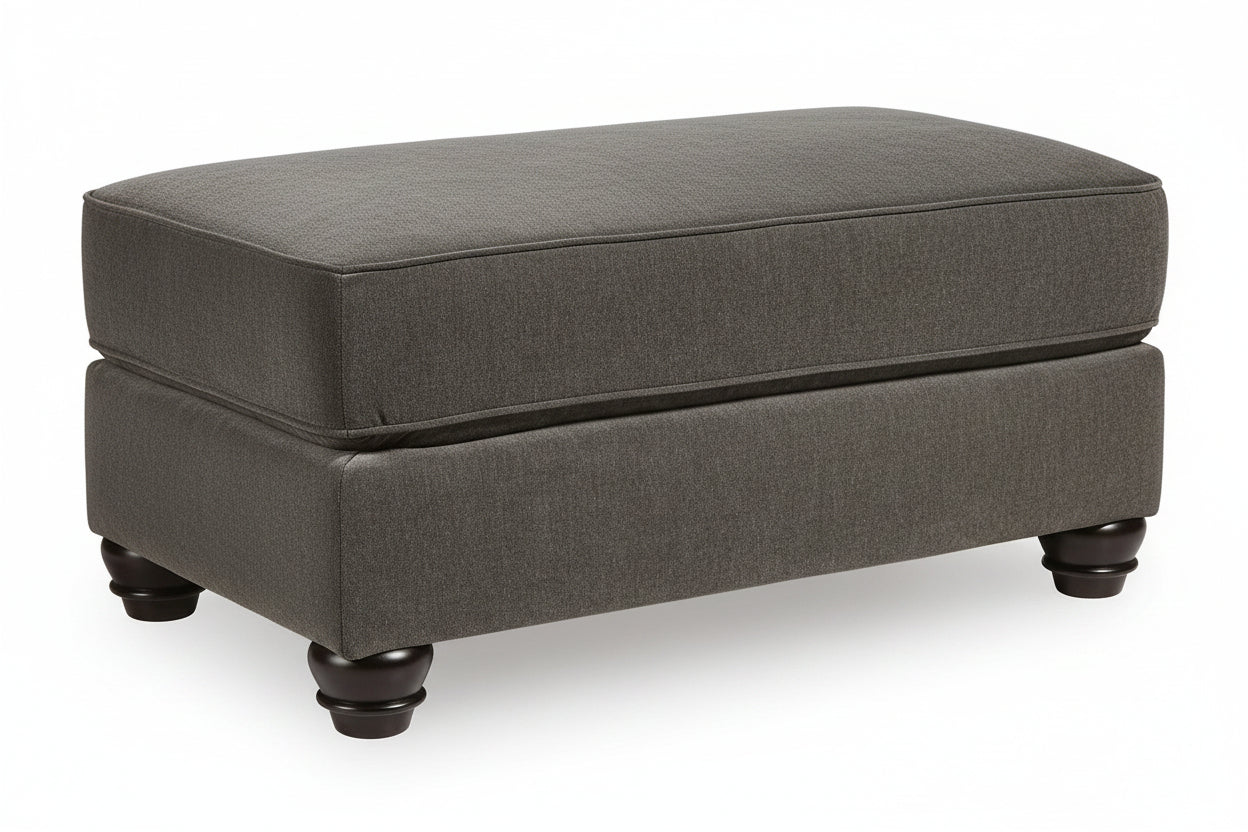 A dark gray upholstered ottoman with dark wooden legs, shown from a front-facing perspective against a white background.