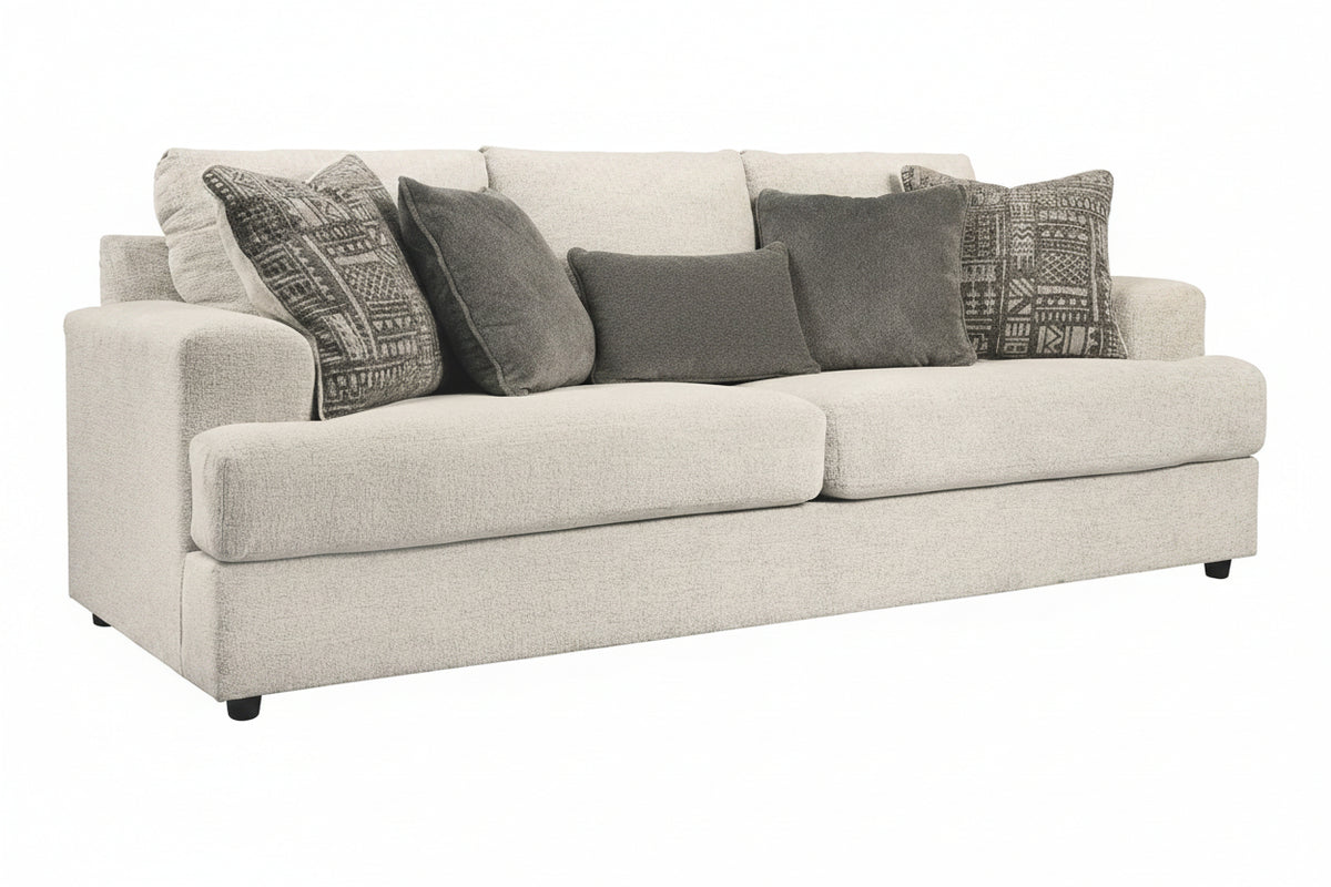 Beige sofa with patterned gray cushions on a white background