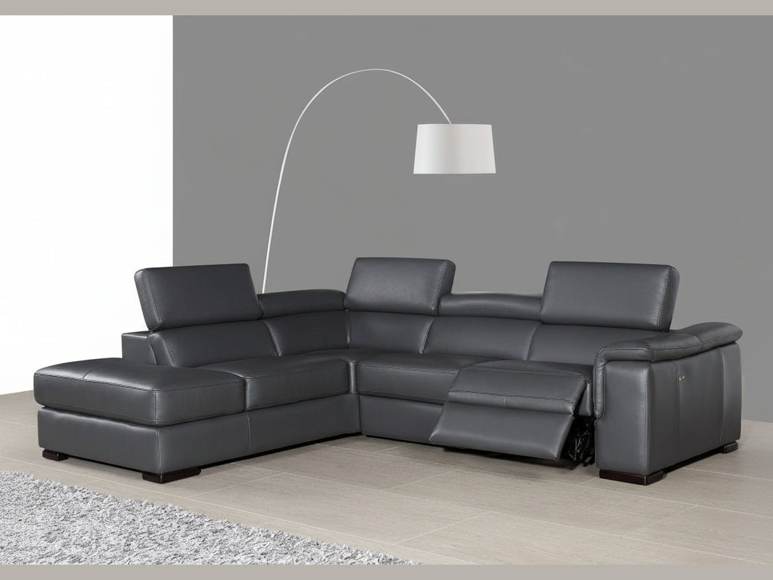 The Agata gray sectional sofa in a living room setting with a lamp and rug.