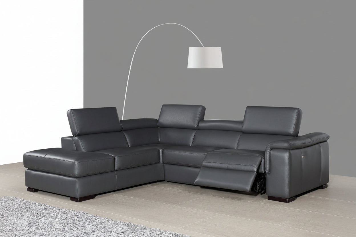 The Agata gray sectional sofa in a living room setting with a lamp and rug.