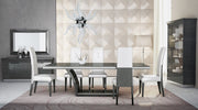 Ariana modern dining room with a glass table and chairs against a decorative wall.