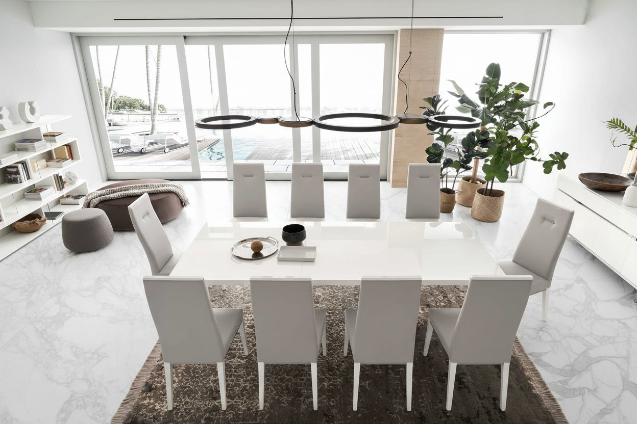 Artemide modern dining room with a long white table and gray chairs in a bright, minimalistic setting.