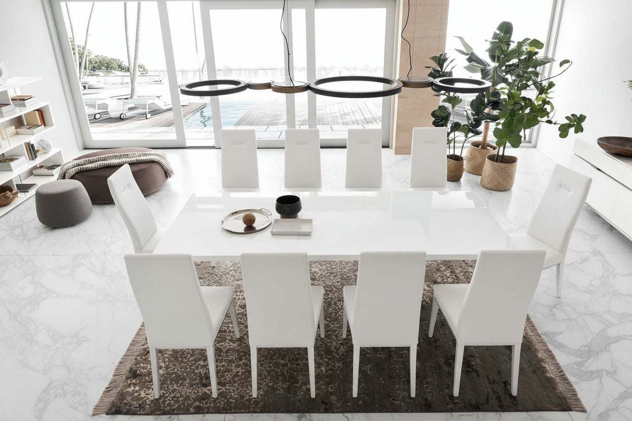 Artemide modern dining room with a long white table and gray chairs in a bright, minimalistic setting.