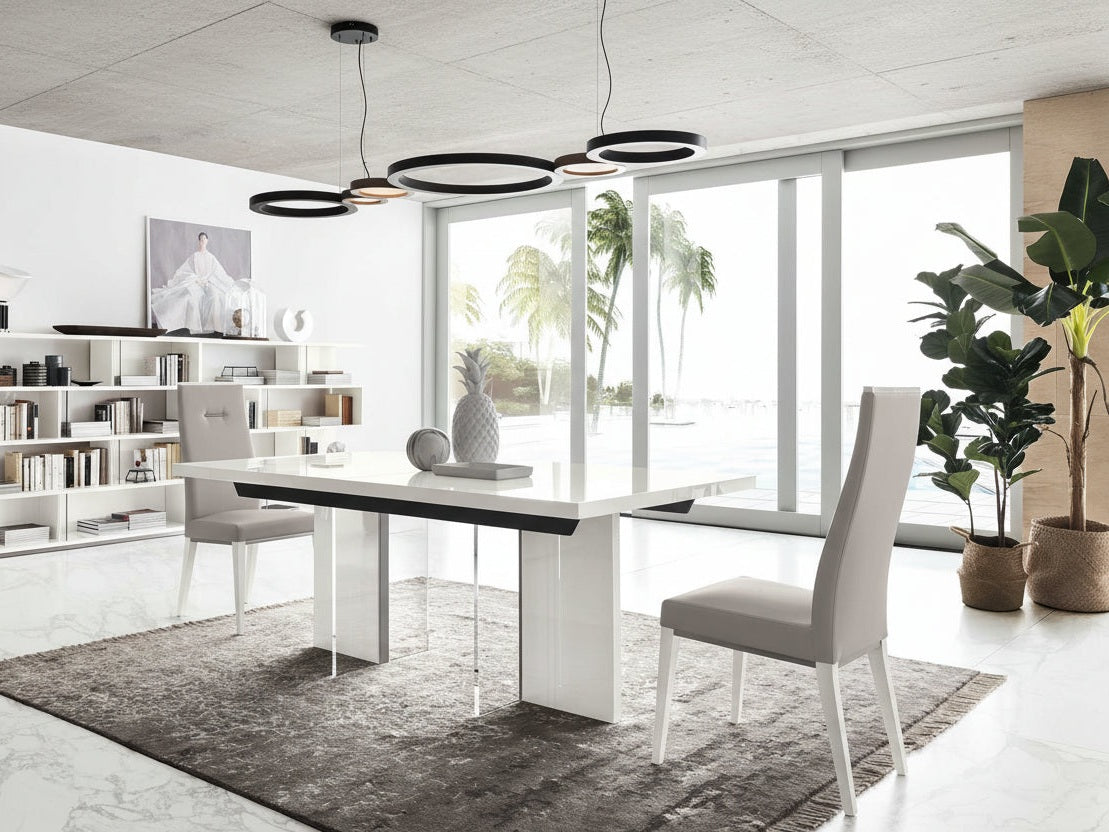 Artemide modern dining room with a white table and gray chairs, large windows, and decorative plants.