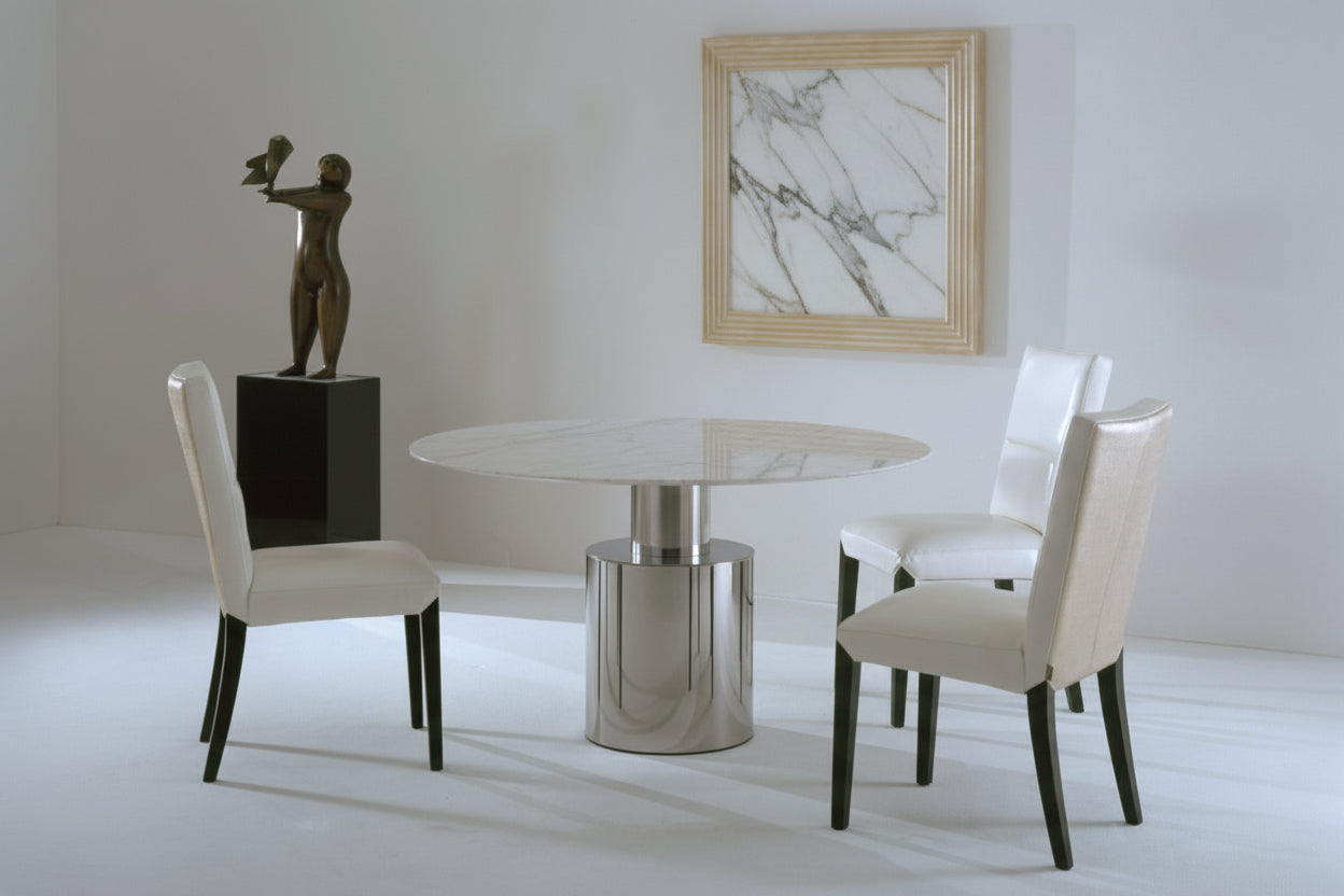 The Athena round dining table and white chairs, featuring a marble-patterned painting on the wall.
