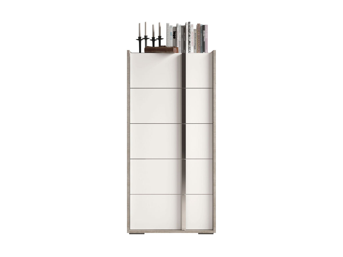 A tall, narrow white cabinet or storage unit with multiple horizontal drawer or door panels and a few books standing on top, shown against a plain white background.