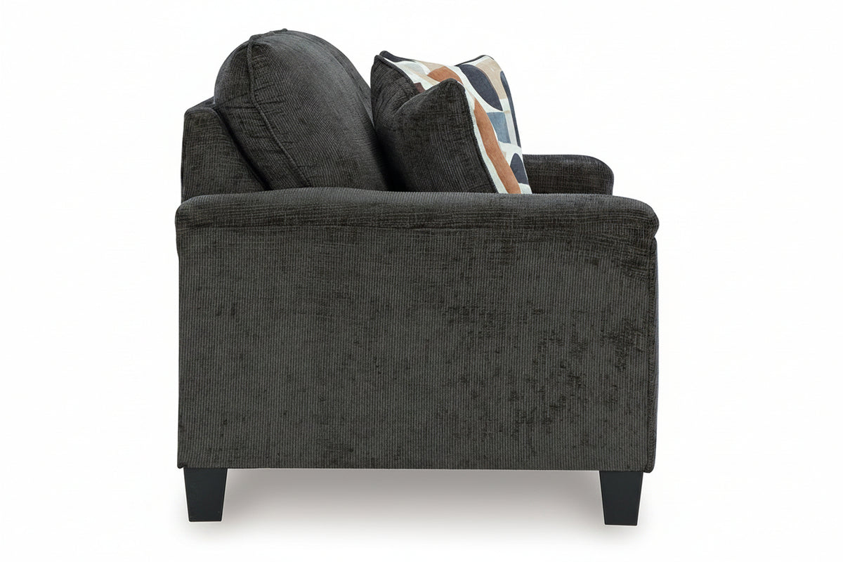 Gray upholstered chair with patterned cushions on a white background