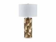 Table lamp with a textured brass base and white shade on a light beige background