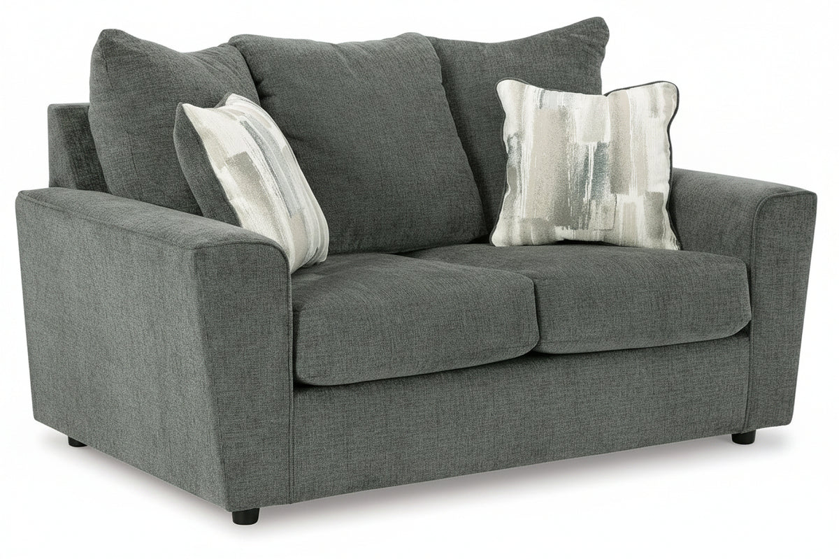 A gray upholstered loveseat with three large back cushions, two seat cushions, rolled arms, and two decorative throw pillows on a plain white studio background.