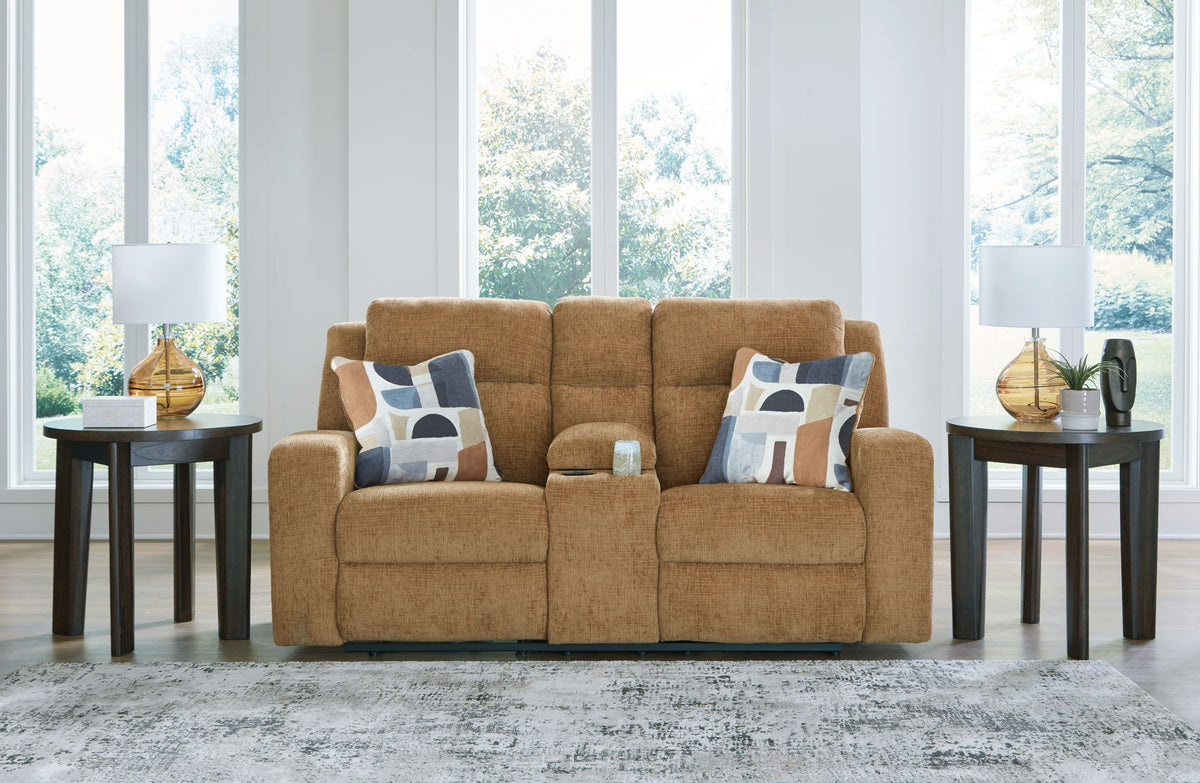 Brown sofa with patterned cushions in a living room setting with large windows.