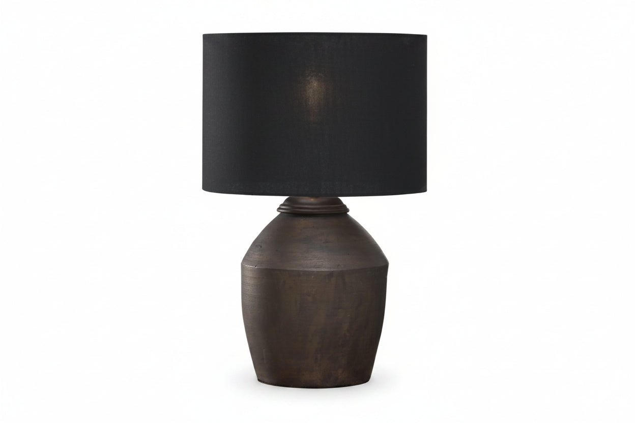 Decorative lamp on a table next to a sofa with a textured pillow