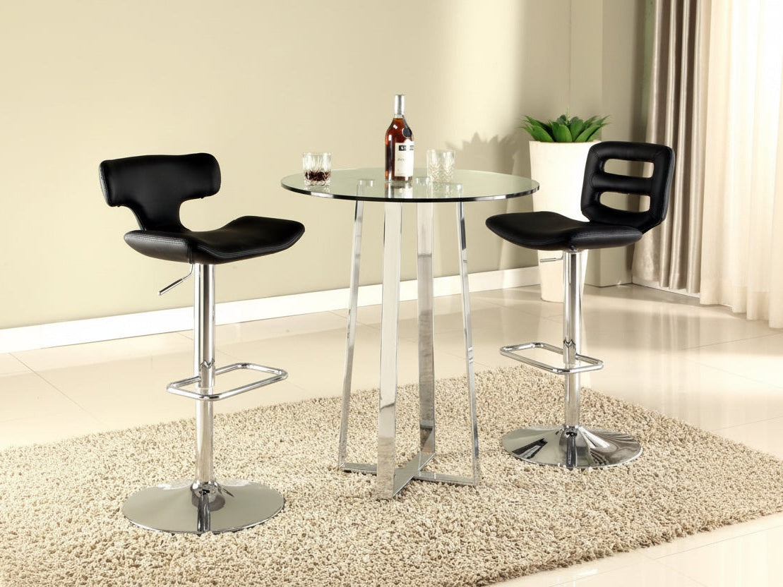 The Chambers two black bar stools with chrome bases in front of a glass dining table.