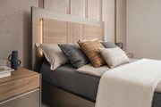 City Life bed with headboard lighting and nightstand, featuring pillows and a vase.