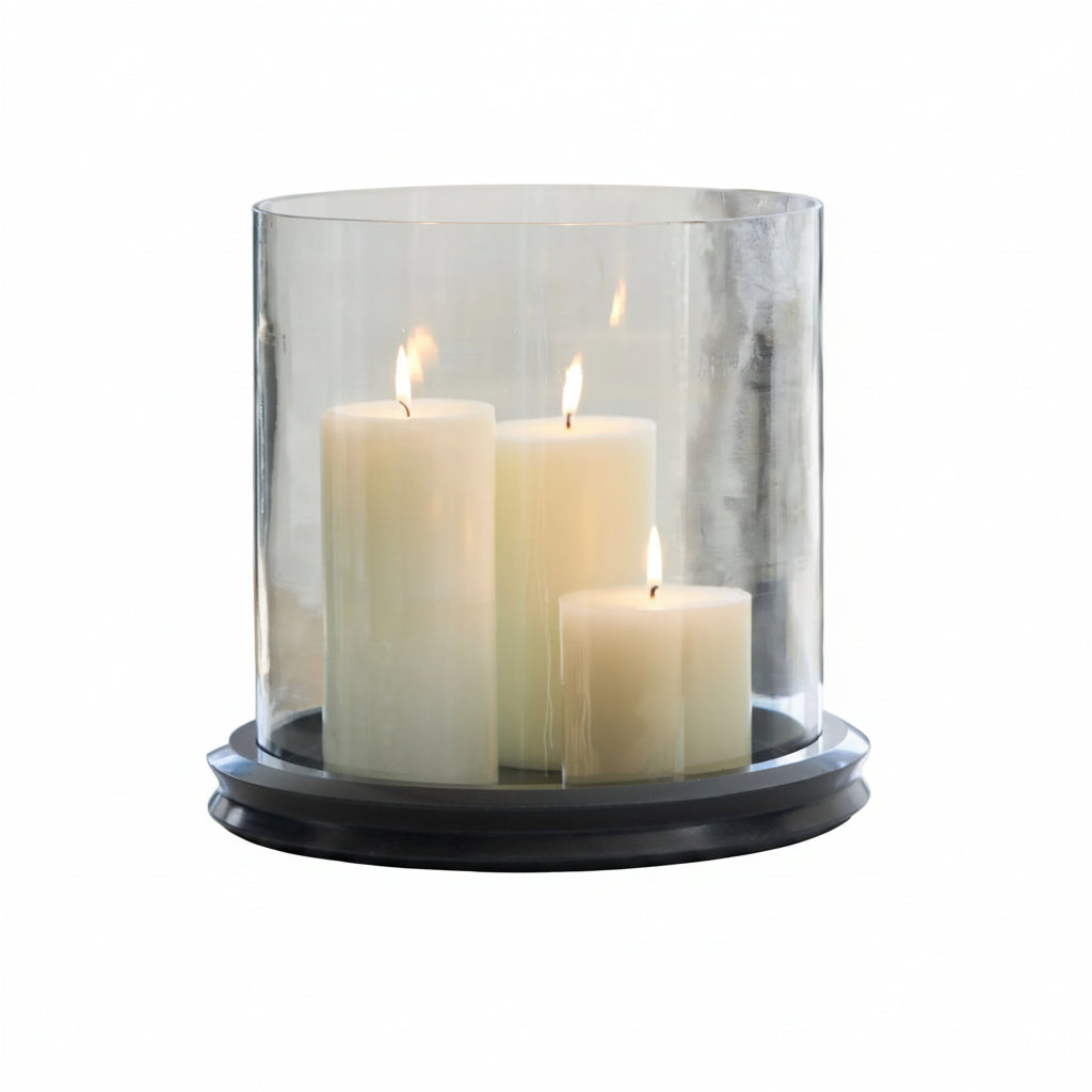 Three candles in a glass holder on a table with a blurred background