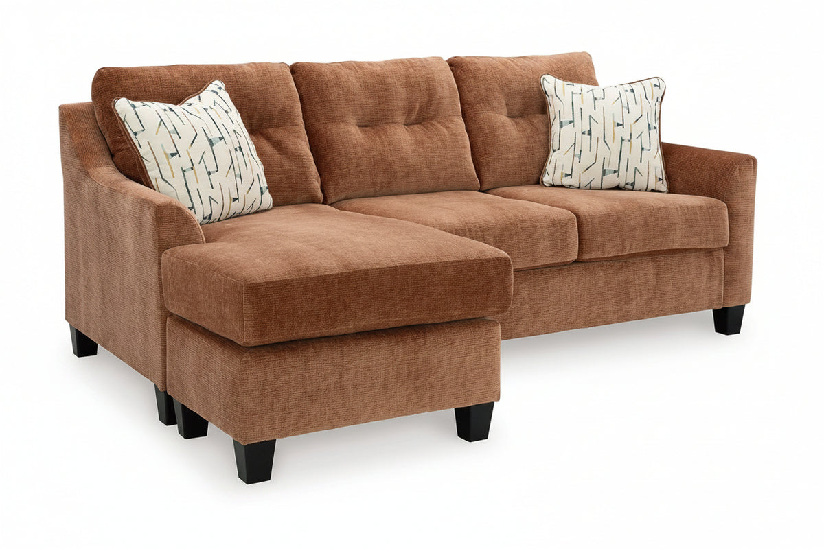 Brown sectional sofa with patterned cushions on a white background
