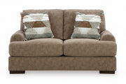 Brown sofa with patterned cushions on a white background