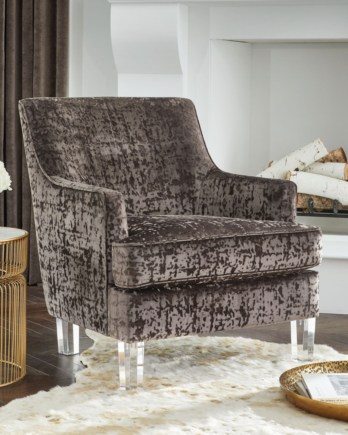 Gray textured armchair with clear legs in a modern living room setting.