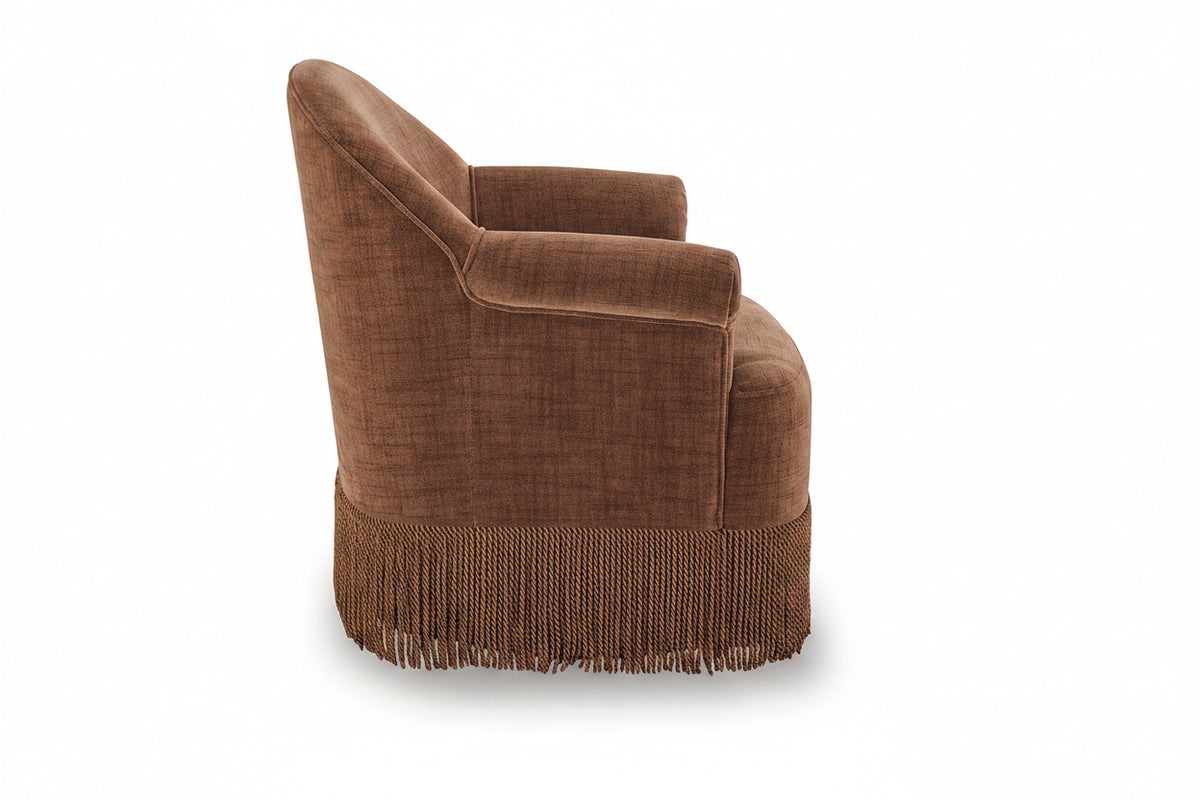 A brown upholstered accent chair with a fringed base, shown from a three-quarter angle against a white background.