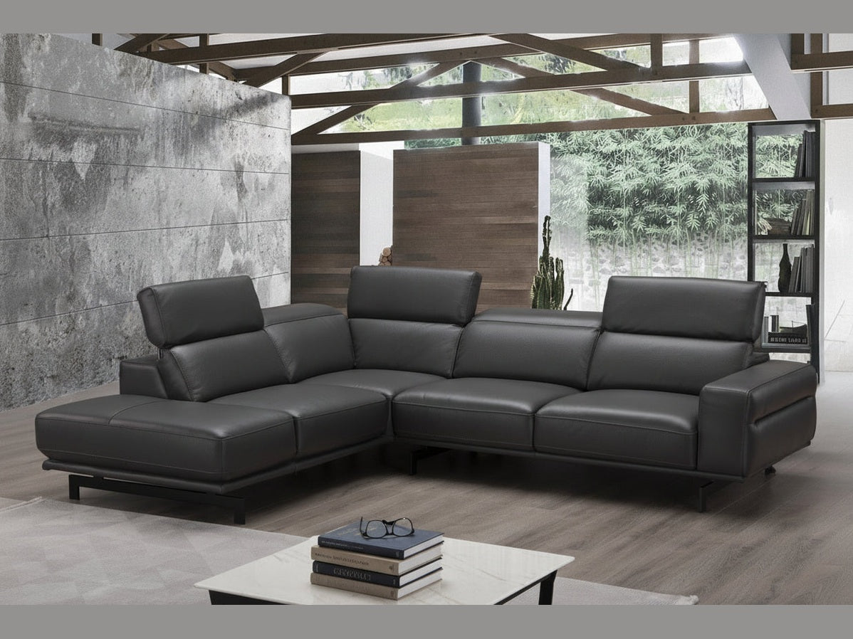 Modern black leather sectional sofa in a living room setting with a coffee table and decor.