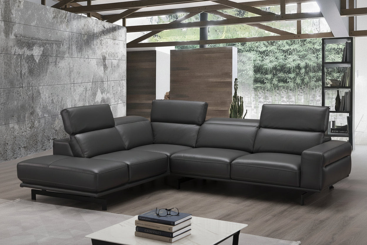 Modern black leather sectional sofa in a living room setting with a coffee table and decor.