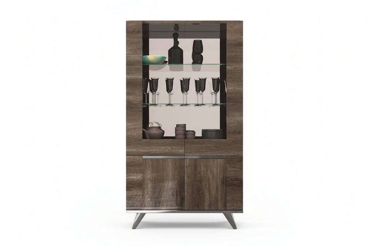A modern tall bar cabinet with a wood grain finish, featuring a glass-front upper section with shelves holding bottles and glasses, and two lower wood-grain doors with slim metal handles.