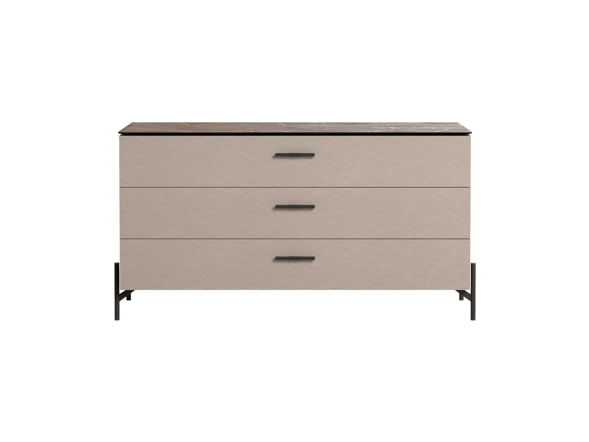 A three-drawer dresser with a light beige textured finish, a dark brown top, and black metal legs and handles, shown against a plain white background.