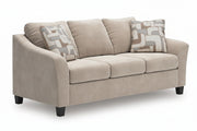A three-seat loveseat sofa upholstered in a warm beige textured fabric, featuring two decorative throw pillows with a beige, gray, and white geometric pattern, set against a plain white background.