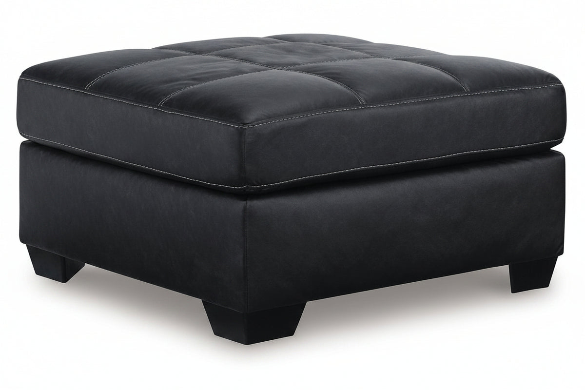 Black tufted ottoman on a white background