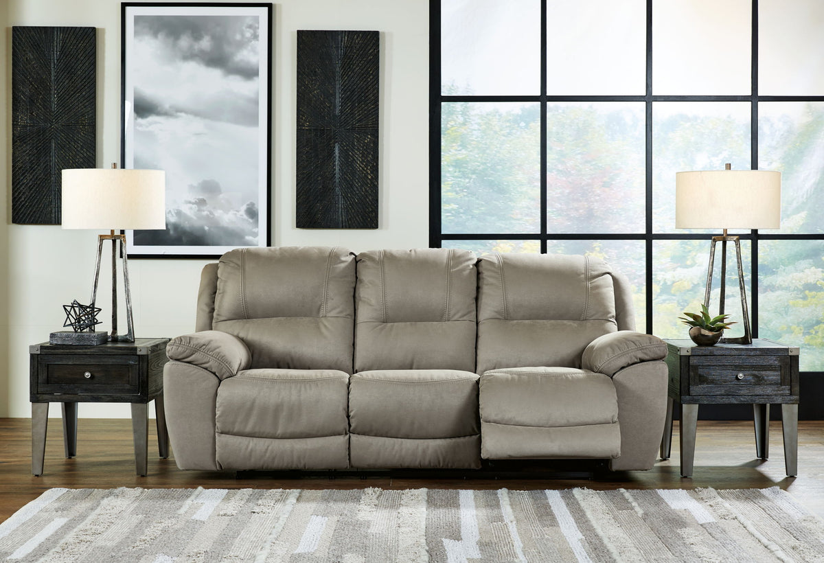 Gray sofa in a living room with side tables, lamps, and wall art.