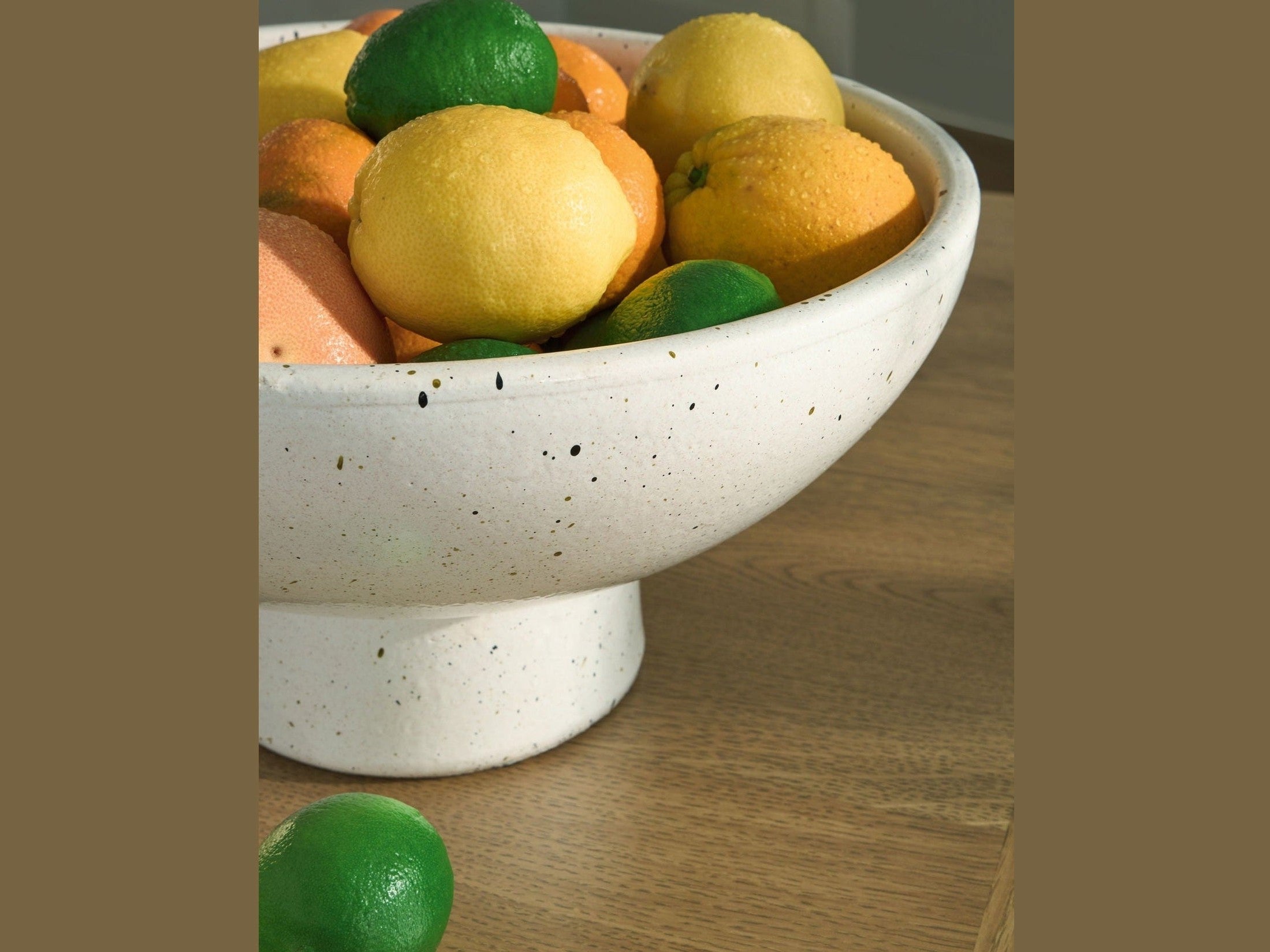 White ceramic bowl filled with fruits on a wooden surface