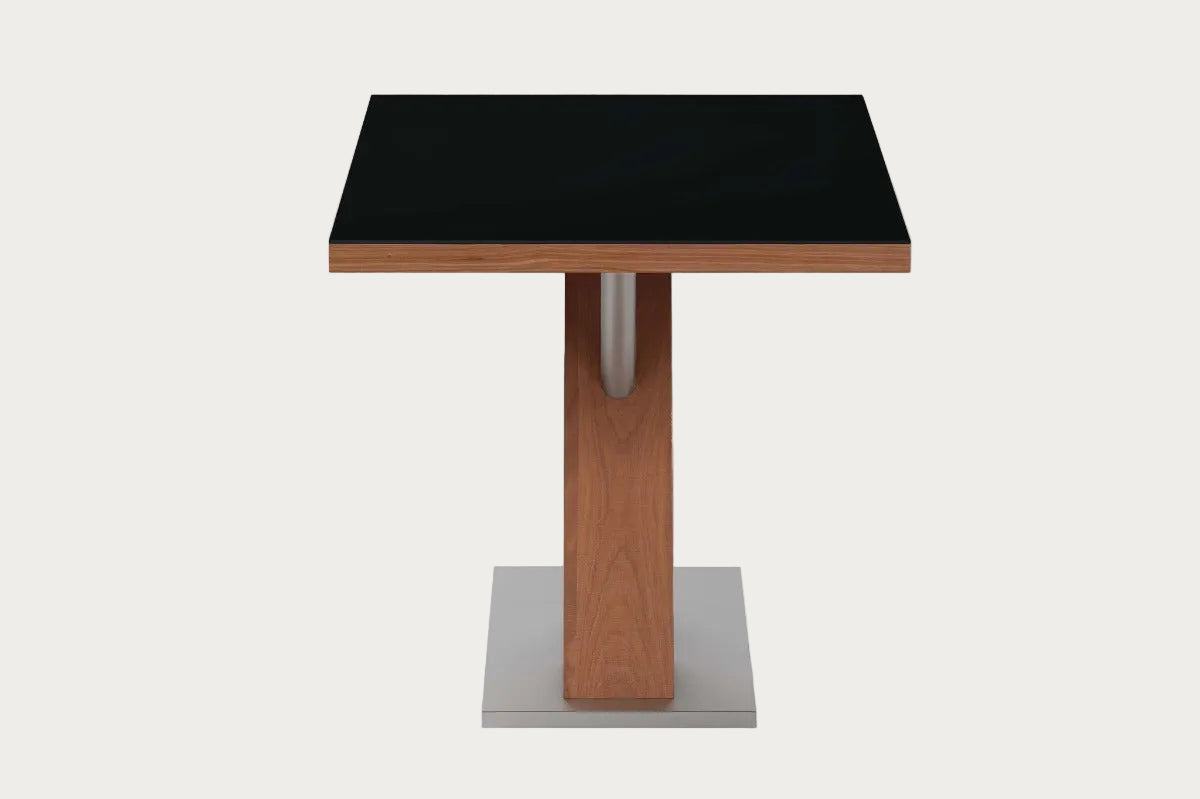 Small table with black top and wooden legs on a white background