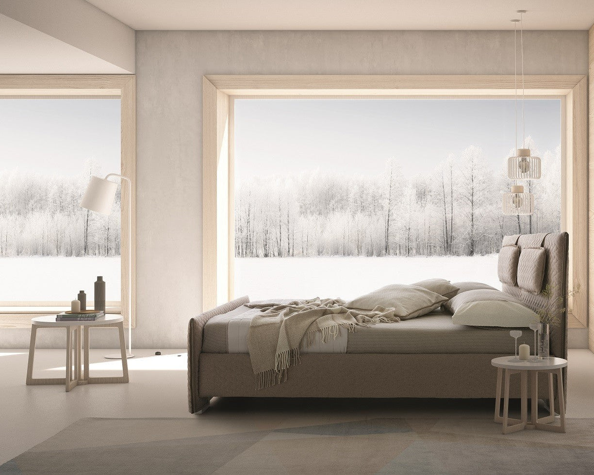 Modern bedroom with a large bed and decorative elements.