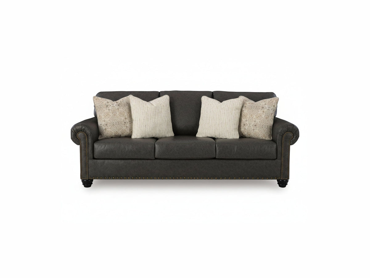 Brown leather sofa with decorative pillows on a white background