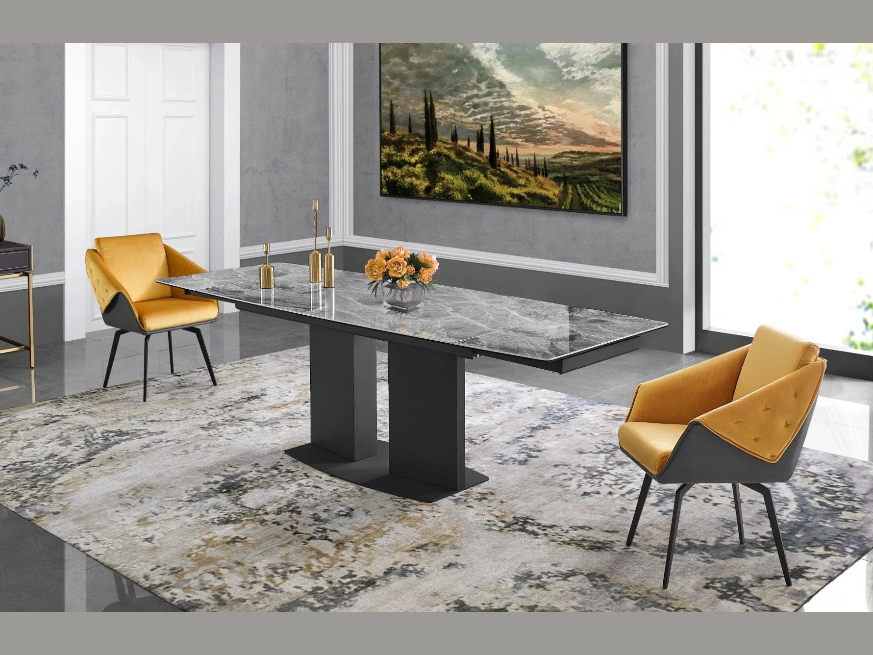 A sleek grey marble dining table with black legs stands on a patterned area rug, flanked by two mustard-yellow velvet chairs in a modern dining room.
