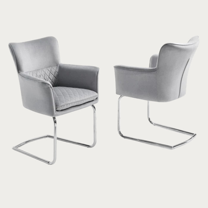 Loran armchairupholstered in light grey fabric with chrome legs