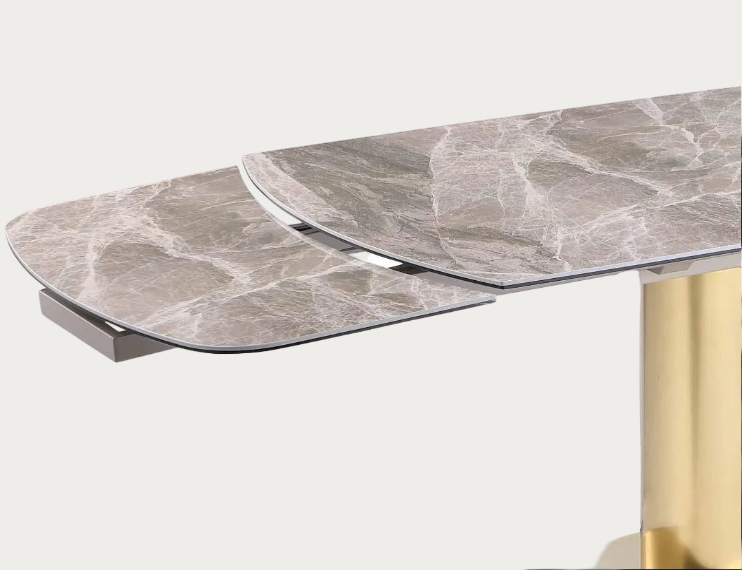 Dining table with marble-like top and gold leg on a white background