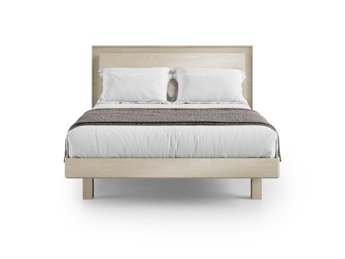 Bed with wooden frame, white bedding, and patterned blanket on a white background