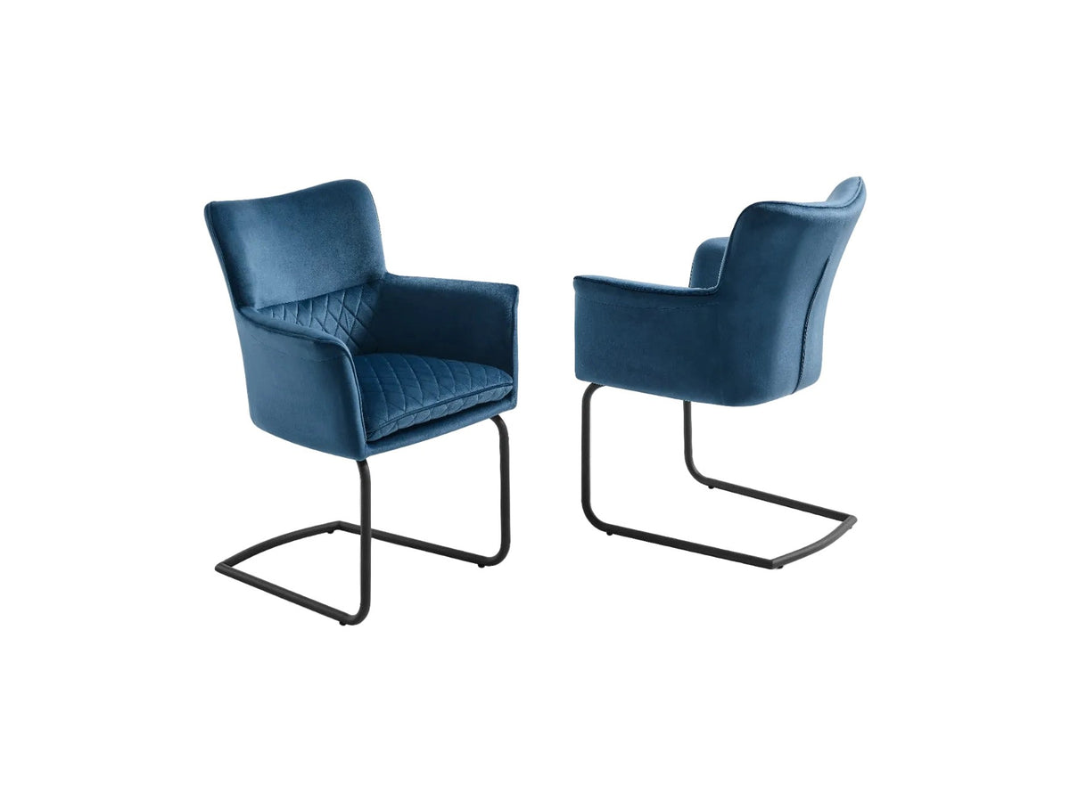 A pair of blue velvet armchairs features diamond-quilted upholstery and sleek black cantilever frames.