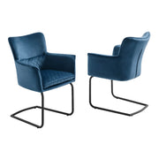 A pair of blue velvet armchairs features diamond-quilted upholstery and sleek black cantilever frames.