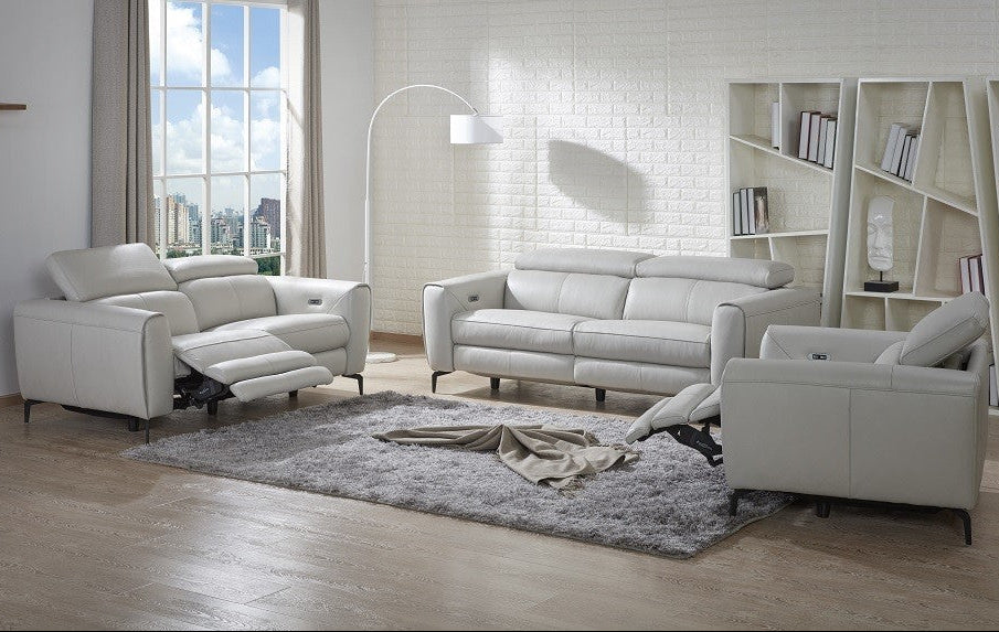 Modern living room with white leather sofa set and bookshelf.