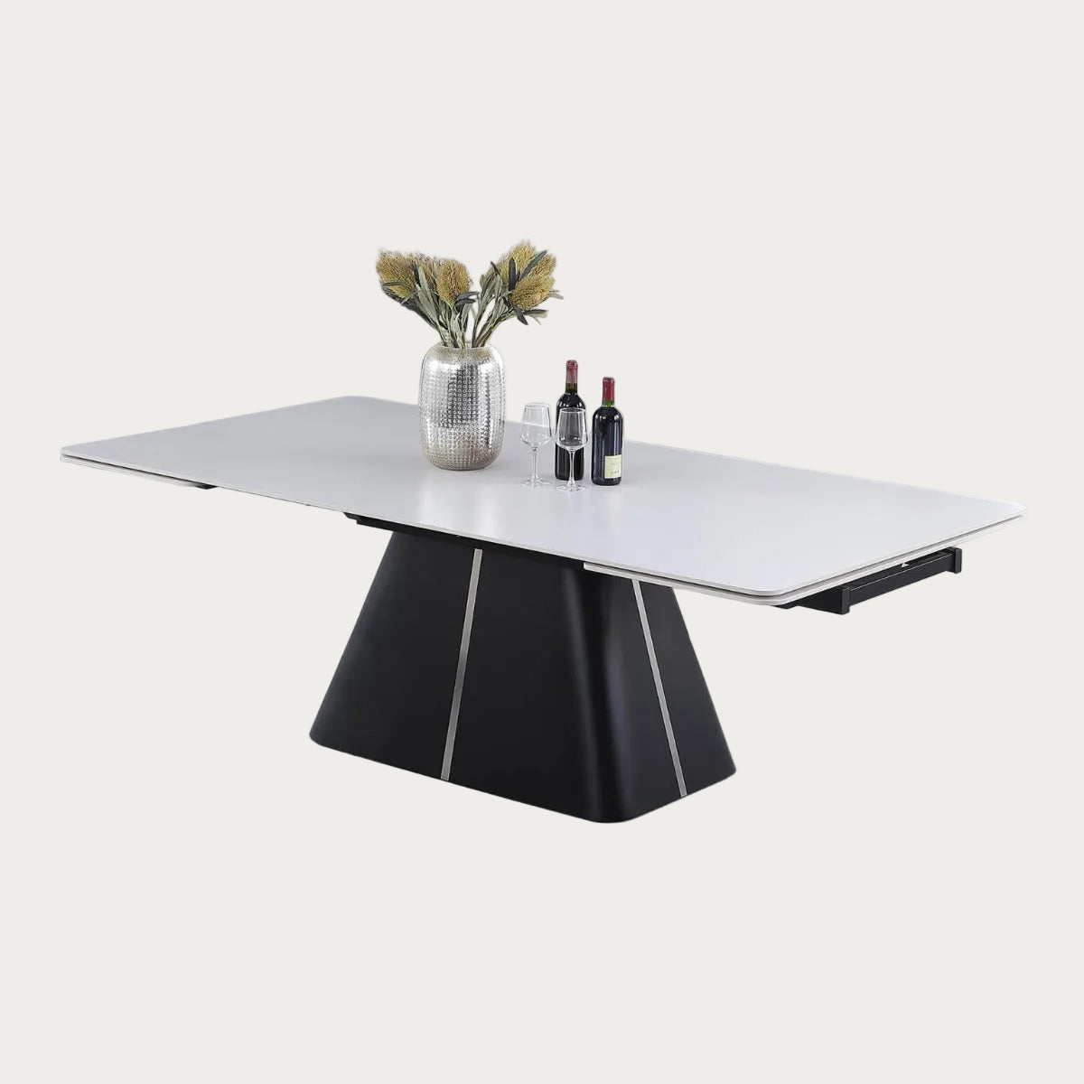 Mabel modern dining table with a black base and white top, featuring a vase and bottles on it.