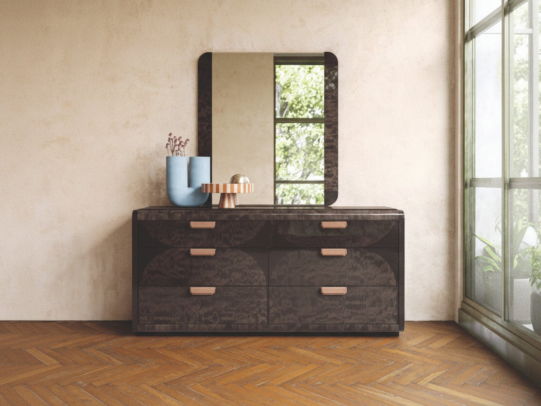 NYX dark wooden dresser with a mirror against a beige wall.