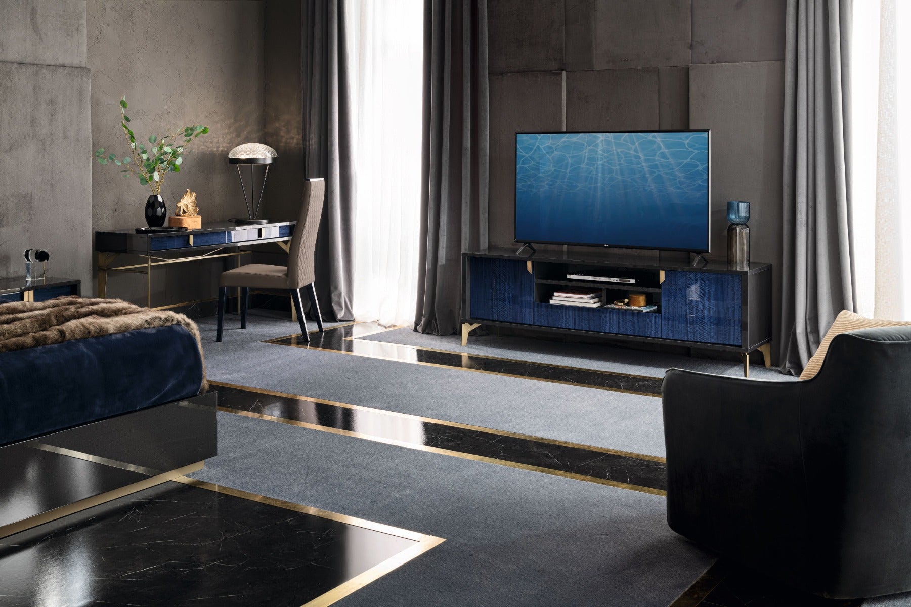 Modern living room with a television on a dark blue stand, surrounded by furniture and decor.