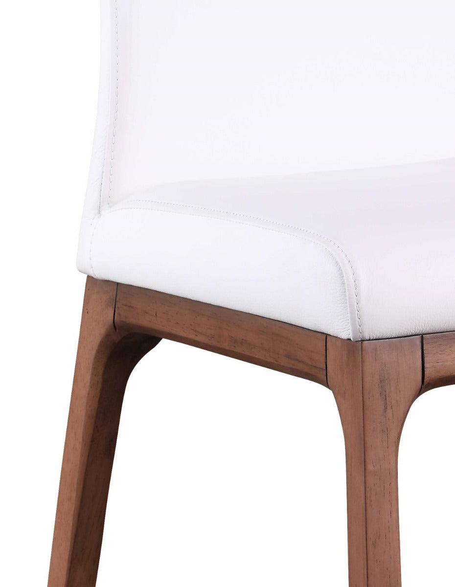 Close-up of a chair with white cushioned seat and wooden legs on a white background