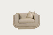 The Sophie beige armchair with a pillow on a white background.
