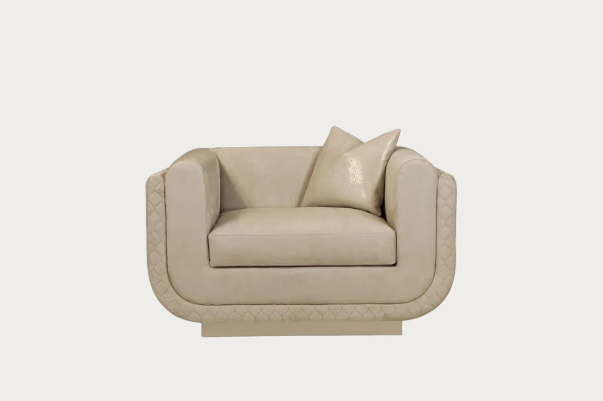The Sophie beige armchair with a pillow on a white background.